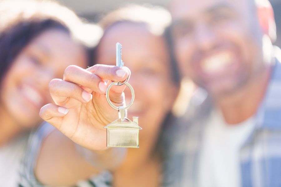 Couple holding eachother looking at their home